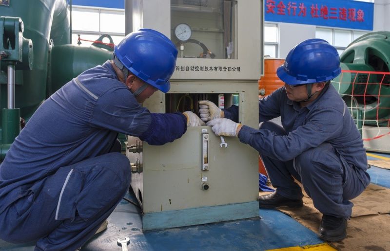 2.靖西供電公司工作人員在峒牌發(fā)電站對(duì)調(diào)整器進(jìn)行檢修維護(hù)。駱衍利攝.JPG